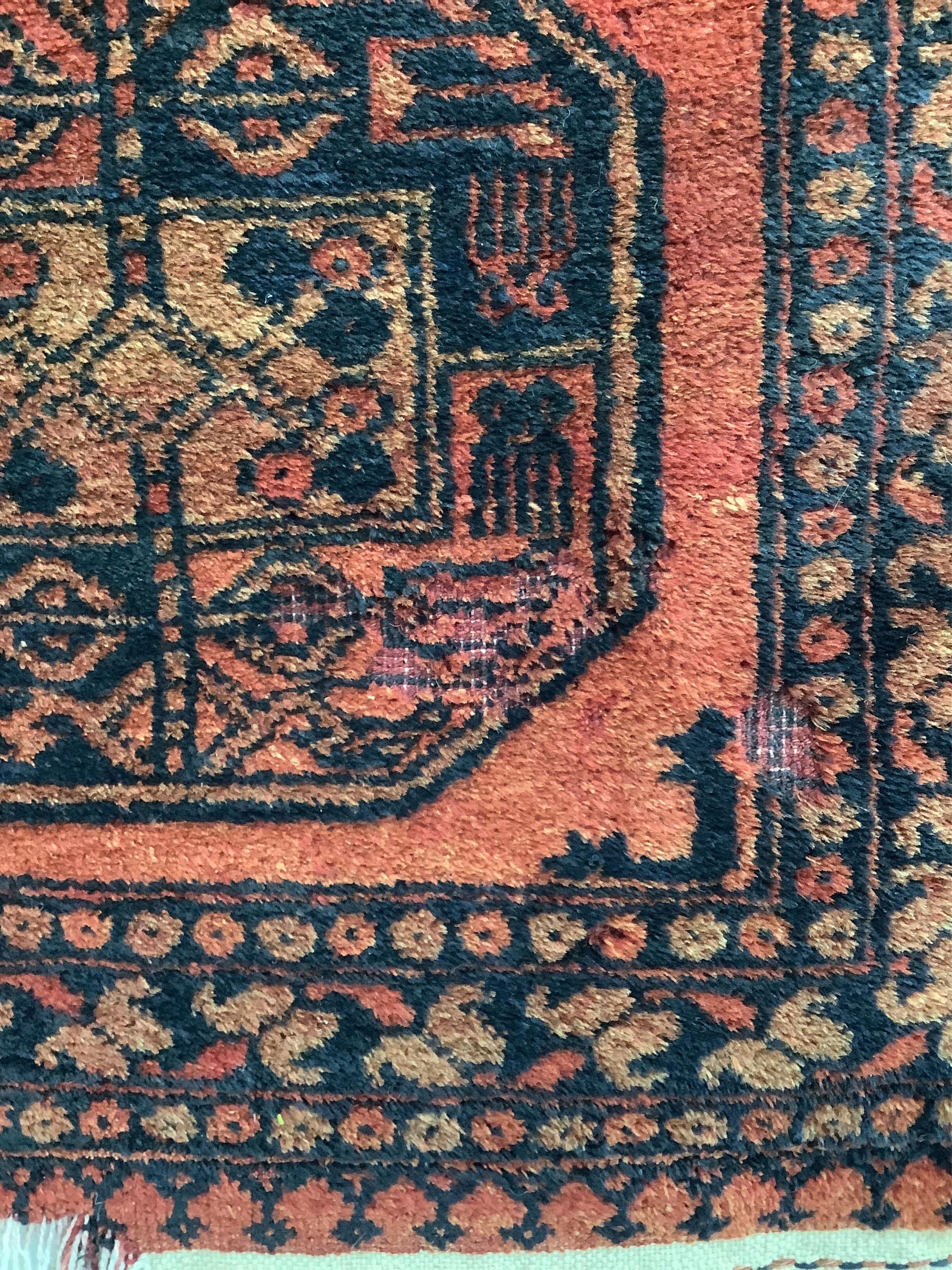 A pair of Afghan red ground rugs, each 144 x 75cm. Condition - fair